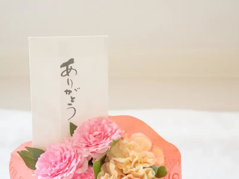 花束とありがとうと書かれた手紙の画像