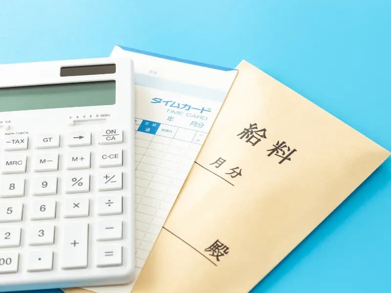 給料復路とタイムカードと計算機の画像