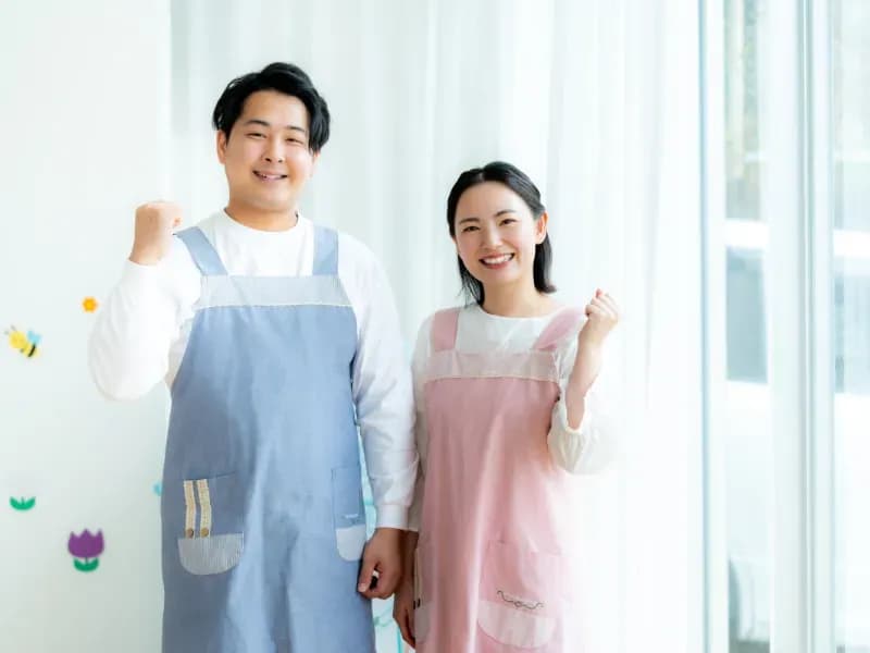 ガッツポーズをする笑顔の男女の保育士のイメージ