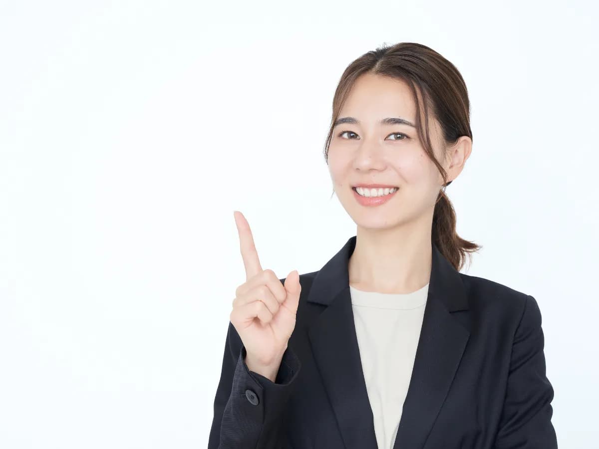 笑顔で指差しをする若いビジネスウーマンの画像