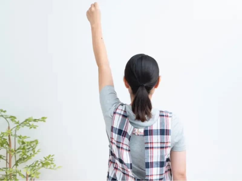 頑張る保育士の背中のイメージ