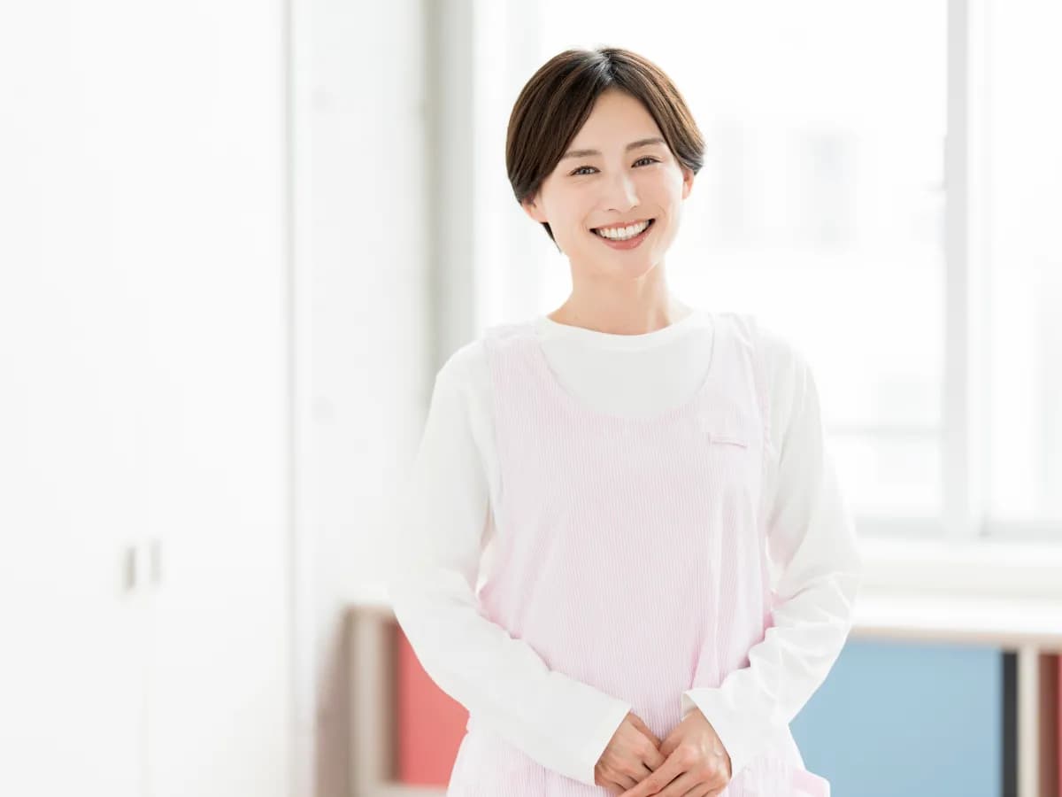 女性保育士がカメラ目線で微笑んでいる画像