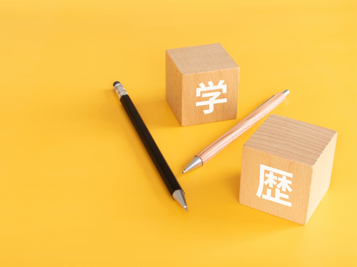 学歴と書かれた積み木とペンの画像