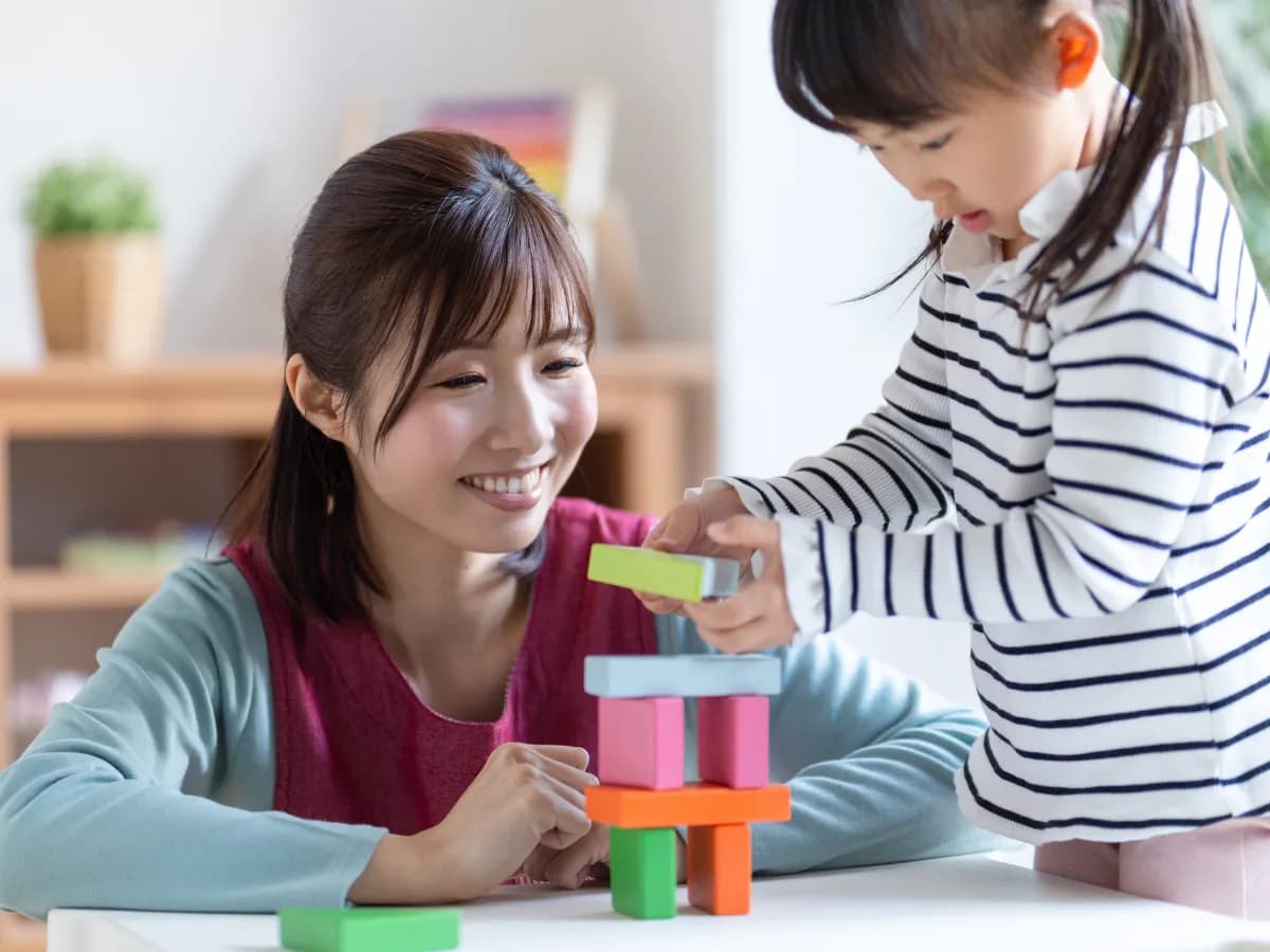 積み木で遊ぶ園児と保育士のイメージ