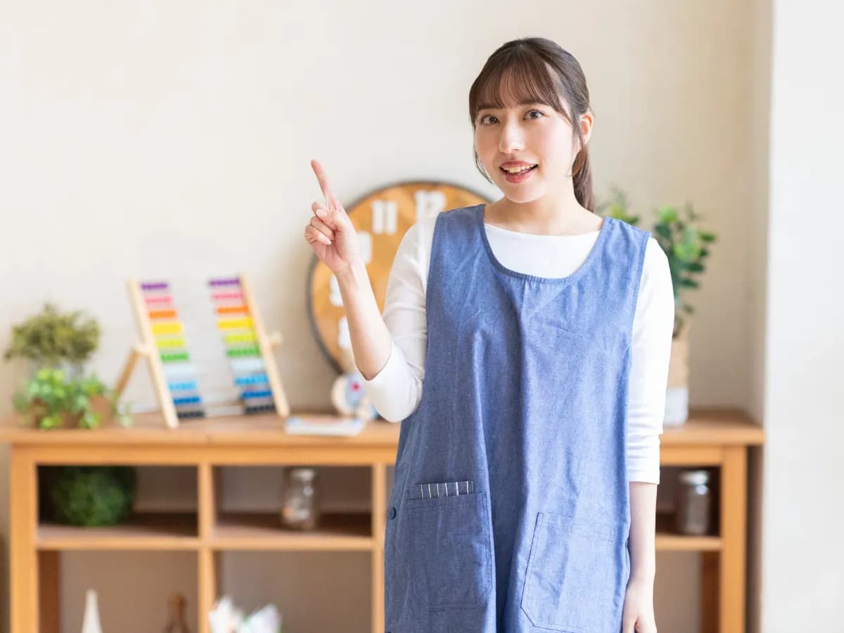 指をさしている女性の保育士のイメージ