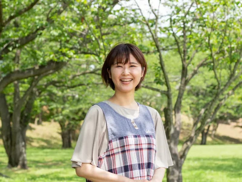 外で笑う保育士の画像