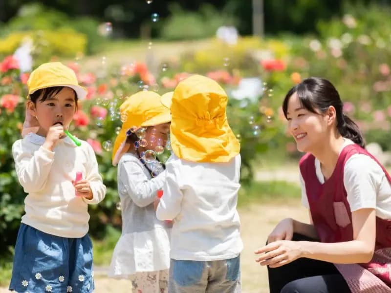 シャボン玉をする幼児と保育士のイメージ