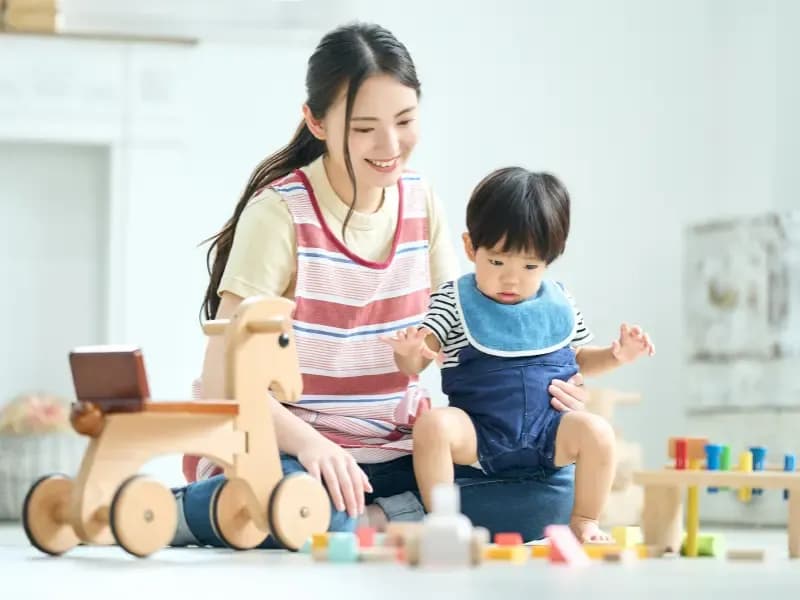 こどもと遊ぶ女性保育士イメージ