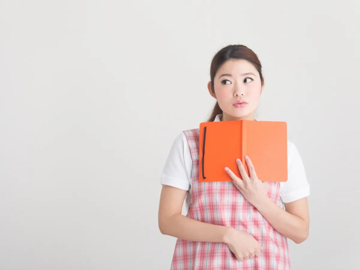 ノートを持ち考えている保育士のイメージ