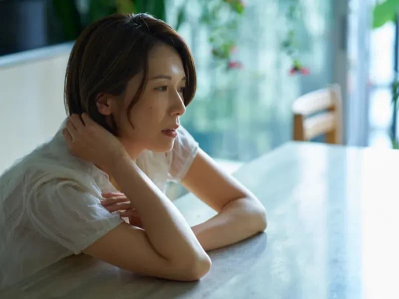虚空を見つめる疲れた女性の画像