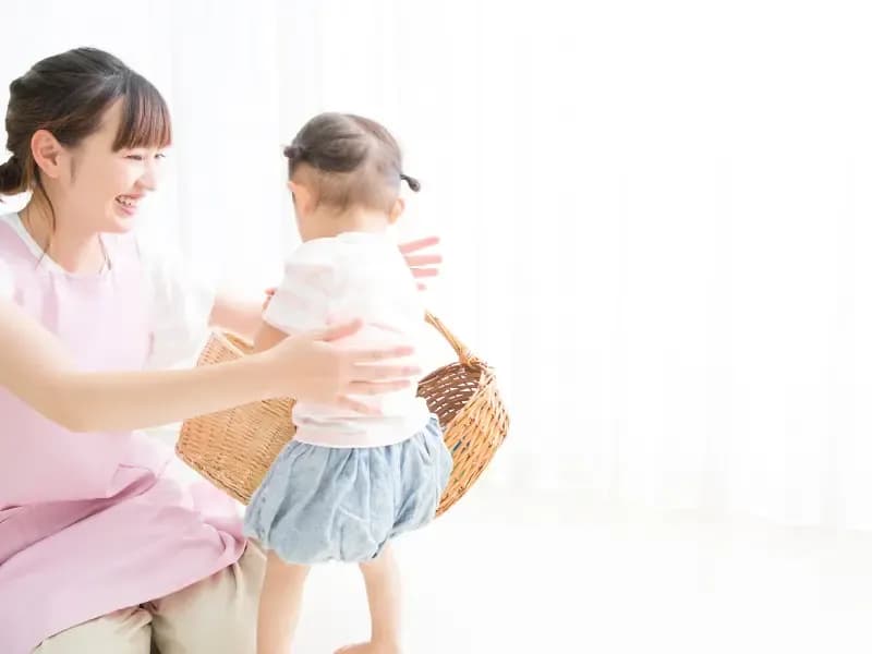 笑顔で子供と遊ぶ保育士のイメージ